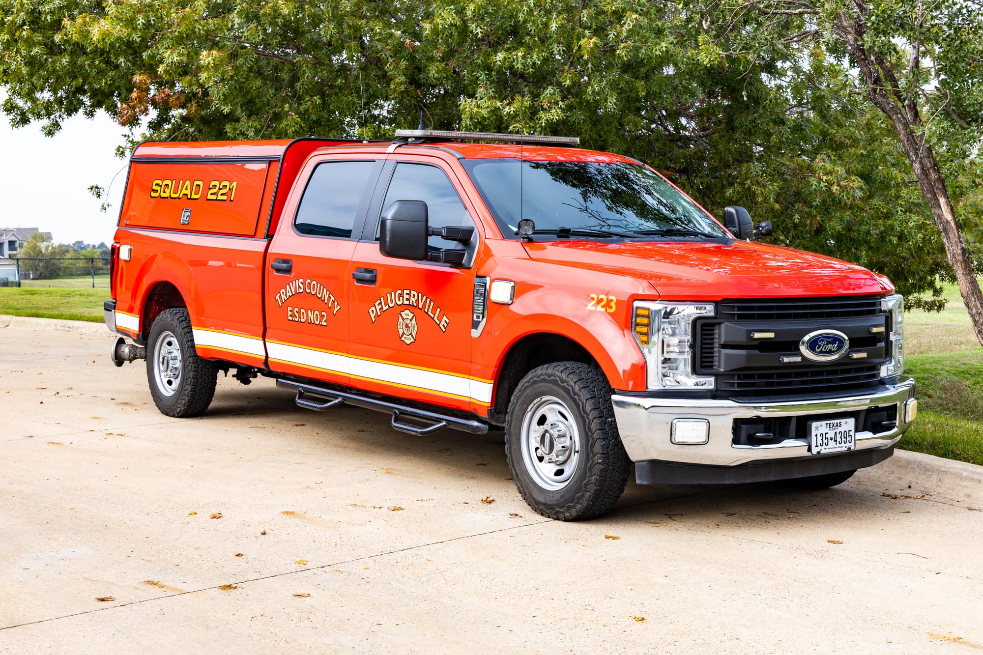 Red Pflugerville Fire Department Squad 221 pickup parked on a concrete drive.