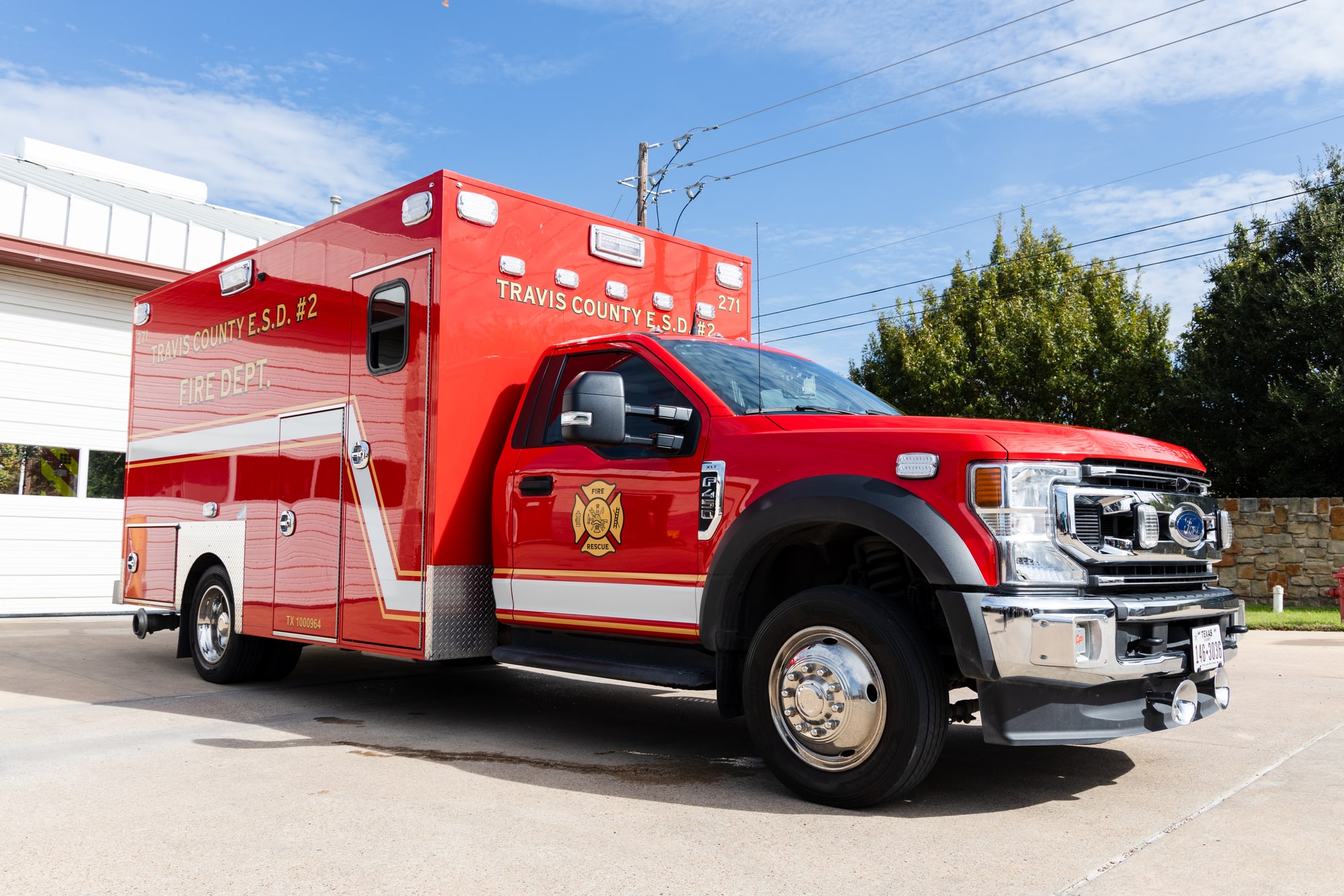 Red Pflugerville Fire Department Medic 231 ambulance parked outside with side compartment open.