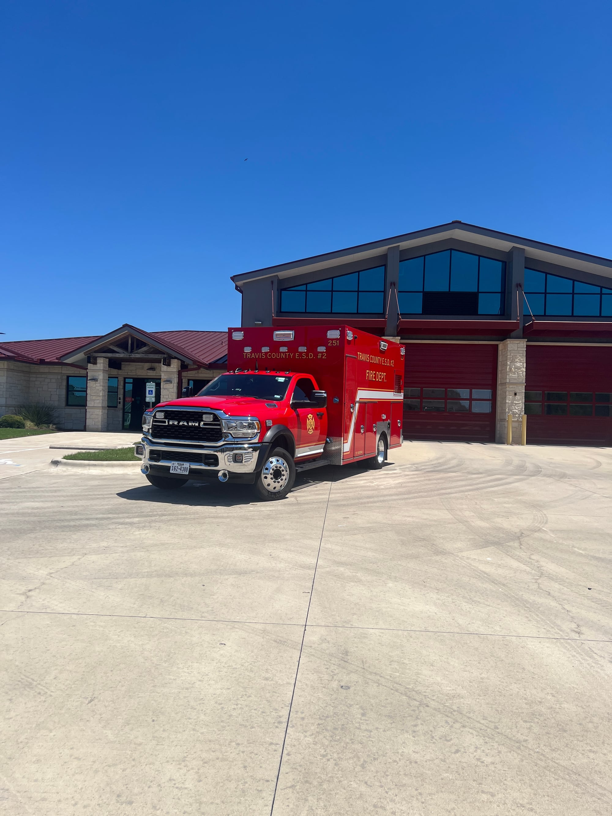 Red Pflugerville Fire Department apparatus parked outside Station 5 on a sunny day.