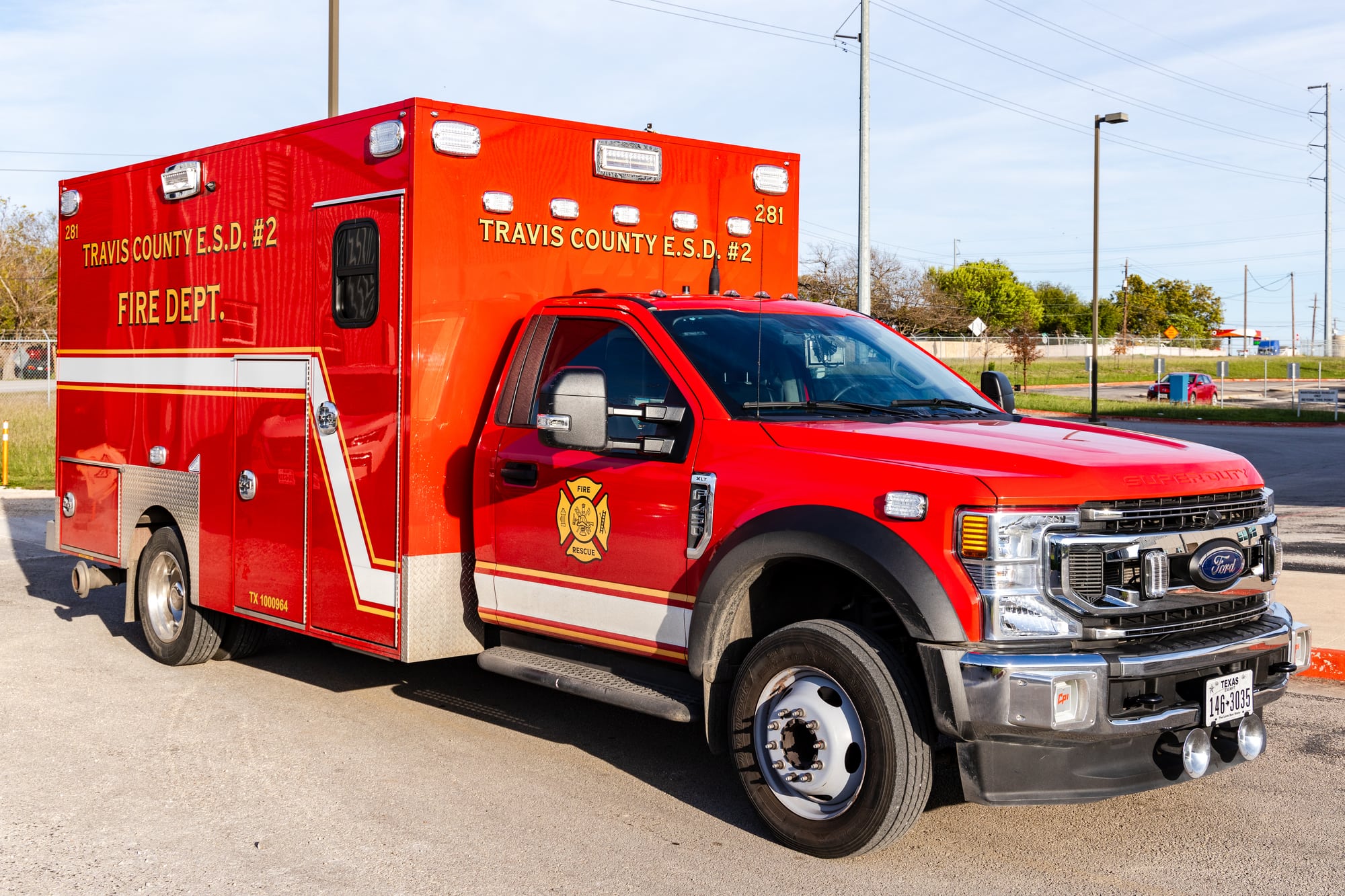 Red Pflugerville Fire Department Medic 281 ambulance parked in a paved lot.