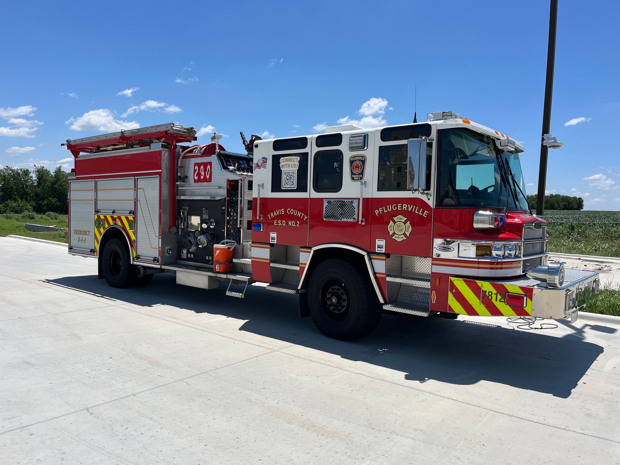 Red and white Pflugerville Fire Department Reserve Engine 290 pumper parked on pavement.